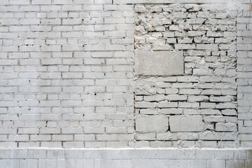 A brick light gray or white wall with a bricked-up passage in a hurry