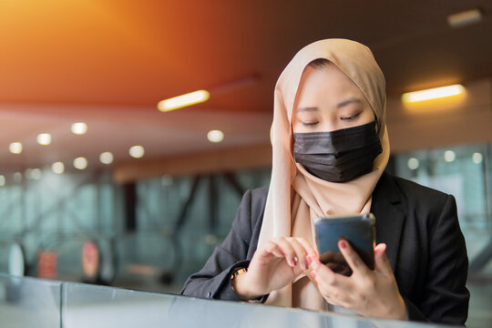 Young Malay Lady Wearing Face Mask Holding Smartphone