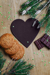 Paper heart for notes with chalk in a Christmas composition. Oatmeal cookies with milk chocolate on...