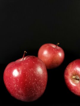 Still life with red apples on black background