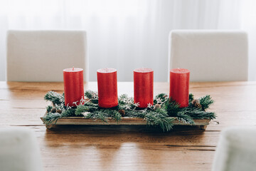 Four Advent candles, festive table arrangement. Swiss tradition to celebrate advent time in December by lighting each candle every Sunday.