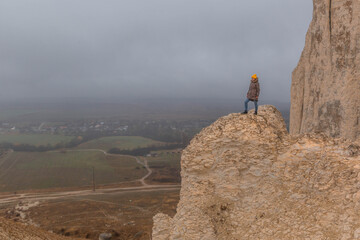 A girl standing on the edge of a cliff. White rock. Crimea