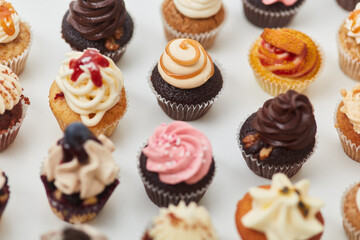 Many different colorful cupcakes with decoration