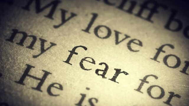 The word fear on an old page in the book is separated from the general text and zooms into the camera. Creative 3D 4k slow motion video animation.