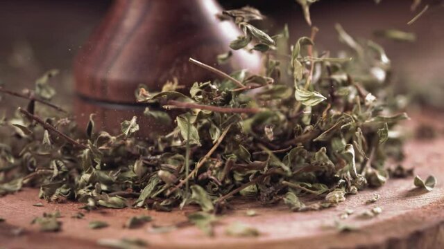Closeup shot of grinding dried thyme leaves using Mortar and Pestle.