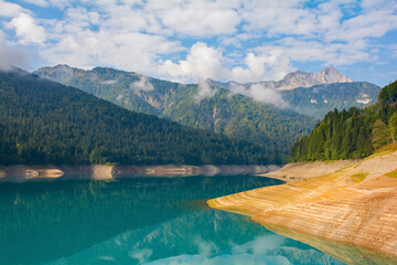 Low water in Sauris Lake, Lago di Sauris, in late September. The lake is artificial, formed by a...