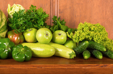 Useful green vegetables on a wooden background.