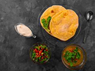 Homemade corn flatbread cilantro greens tomato salsa. Handmade mexican Tortilla Taco Quesadilla vegetable. Traditional Indian Makki ki roti bread top view. Gluten free flour dough authentic cuisine.