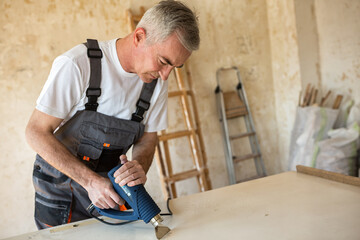 Workerr repairs the door in a carpenter's workshop
