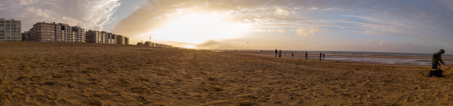 Lowangle panorama of the beach of Sint-idesbald with a lot of sand in the foreground in autumnal evening light