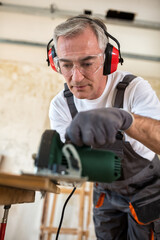 Fototapeta premium Carpenter working with wood plank at workshop