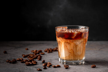 Ice coffee in a glass with cream poured over.