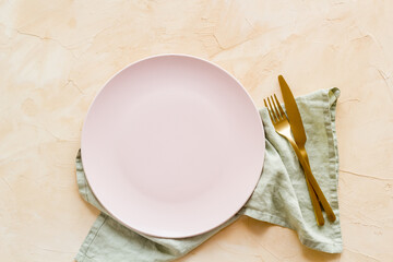 Empty dish and cutlery on napkin. Table setting top view