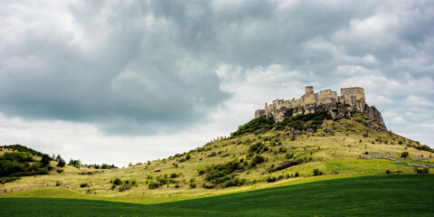 spis, slovakia - 29 APR 2019: castle ruins on the hill. grassy meadow in the foreground. popular travel destination on a cloudy day