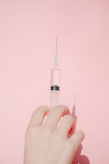 A hand holding a syringe with medicine in it.