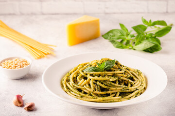 Pasta spaghetti with pesto sauce and fresh basil leaves
