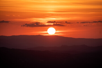 Fototapeta premium Beautiful orange sunset. Sunset in Sardinia. Red sky over hills. Aurora effect. 