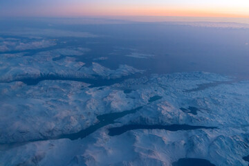 Fototapeta premium Aerial view on snow covered mountains and glaciers in Greenland coastal area