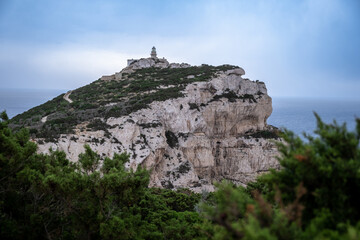 Capo Caccia lighthouse. Lighthouse on high rocky cliff next to the ocean in Sardinia Italy. 