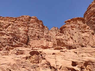 Dans la zone protégée du désert de Wadi Rum en Jordanie, avec de hautes montagnes rocheuses, exploration dans l'inconnu, sous un soleil et forte chaleur, escalade, faille ou crevasse rocheuse