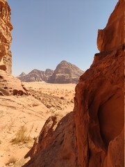 Dans la zone protégée du désert de Wadi Rum en Jordanie, avec de hautes montagnes rocheuses, exploration dans l'inconnu, sous un soleil et forte chaleur, escalade, abri dans l'ombre, pour se reposer