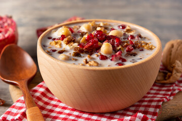 Traditional Turkish Noah's pudding in bowl on wooden table	