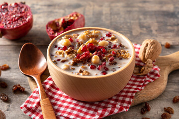 Traditional Turkish Noah's pudding in bowl on wooden table	