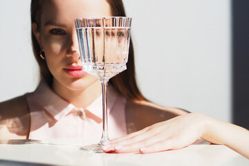 Conceptual surreal portrait Caucasian woman looking through glass of water