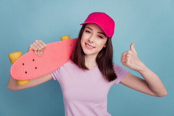 Photo of young girl show thumb-up suggest select ad longboard sportive isolated turquoise color...