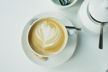 a cup of late coffee with flower shape design on top at cafe 