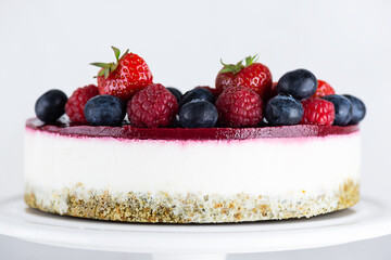 Raw mousse cake with berries on a light background. Sugar, gluten, lactose free, vegan.