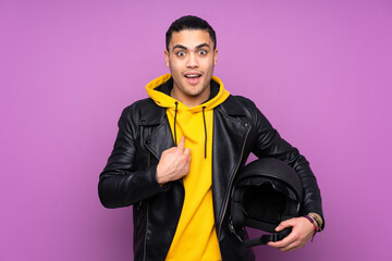 Man with a motorcycle helmet isolated on purple background with surprise facial expression