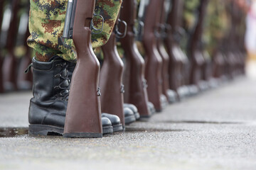 Soldiers in boots and a rifle.Soldiers stand in row. Gun in hand. Army, Military Boots lines in camouflage uniforms