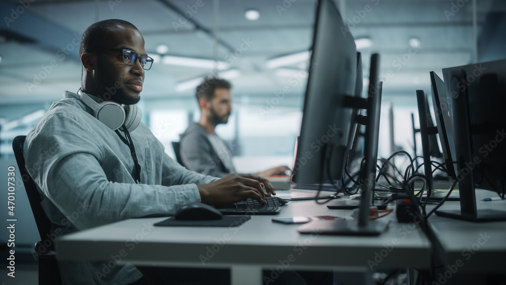 Leinwandbilder Diverse Office: Black IT Programmer Working on Desktop Computer. Male Specialist Creating Innovative Software Engineer Developing App, Program, Video Game. Terminal with Coding Language.
