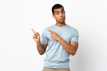 African American man over isolated white background frightened and pointing to the side