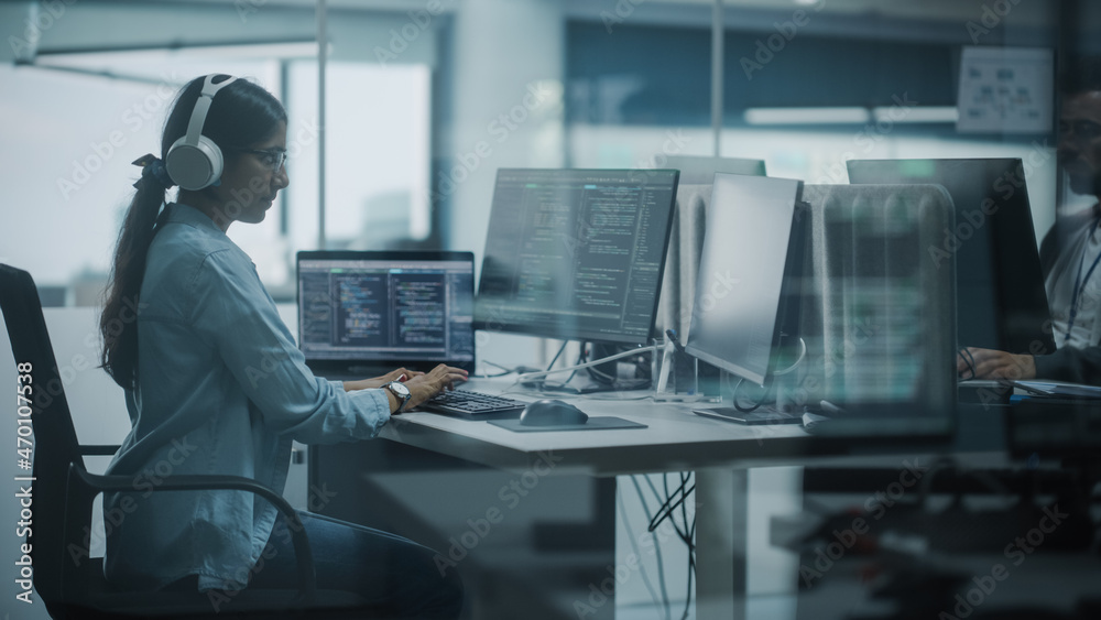 Poster Diverse Office: Indian IT Programmer Working on Computer. Female Specialist Creating Innovative Software. Engineer Developing App, Program, Video Game. Wearing Headphones Listening Podcast, Music