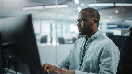 Real Office: Professional Black IT Programmer Working on Desktop Computer. Male Website Developer...