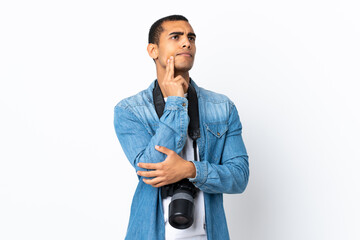 Fototapeta premium Young African American photographer man over isolated white background thinking an idea