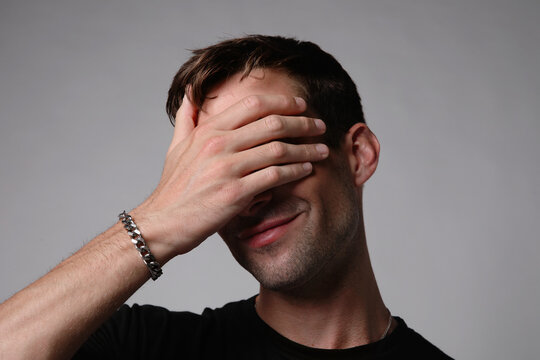 Portrait of sad young man covering his face with hand.Suicide thoughts.