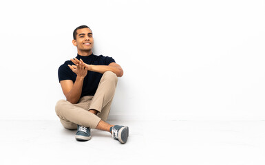 Obraz premium African American man sitting on the floor applauding after presentation in a conference
