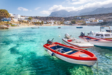 Boats at greek fishing village with beach, Lefkos, Greek Islands