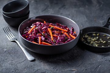 Red cabbage slaw salad with carrot nad pumpkin seeds.