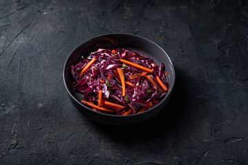 Red cabbage slaw salad with carrot nad pumpkin seeds.