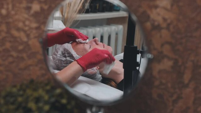 Wipe the mask off the face of a girl with problematic koja with cotton pads.