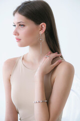 Trendy silver earrings bracelet and ring on a beautiful young girl with long dark hair. Beauty and fashion 