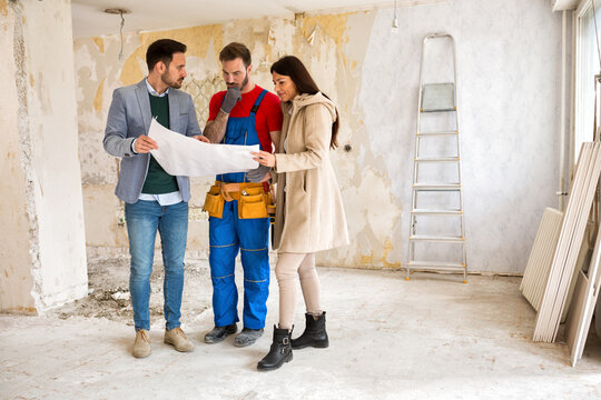 Young couple shows to builder handyman problem about renovations their home
