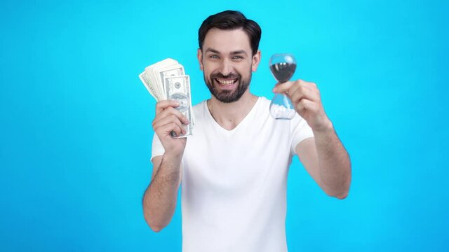 Guy hold money hour glass not miss earnings isolated blue color background