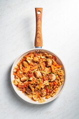 One pan dish. Pasta with onion, red pepper, garlic, tomatoes, carrot and meatballs. White background copy space. Text space.