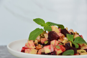 Close up photo of homemade beets and apples salad against white marble background