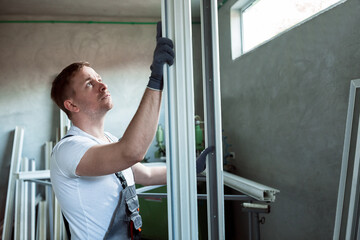 Fototapeta na wymiar Worker in the workshop for making PVC doors and windows.